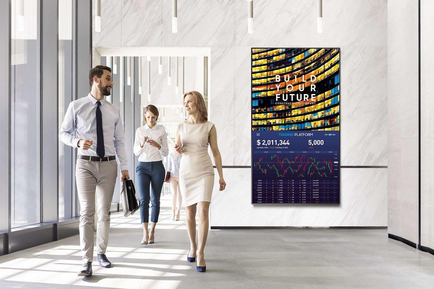 a group of people walking through a building with a large poster